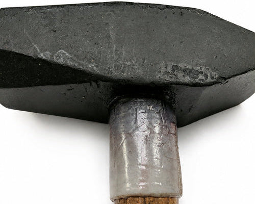 Close-up of a hammer head and part of its wooden handle against a plain white background.