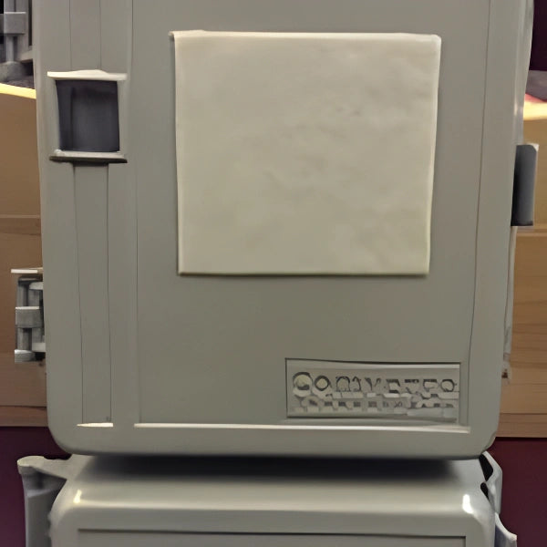 A vintage beige Conveyer 750 industrial machine with a large white square sheet attached to its front panel, photographed in an indoor setting.